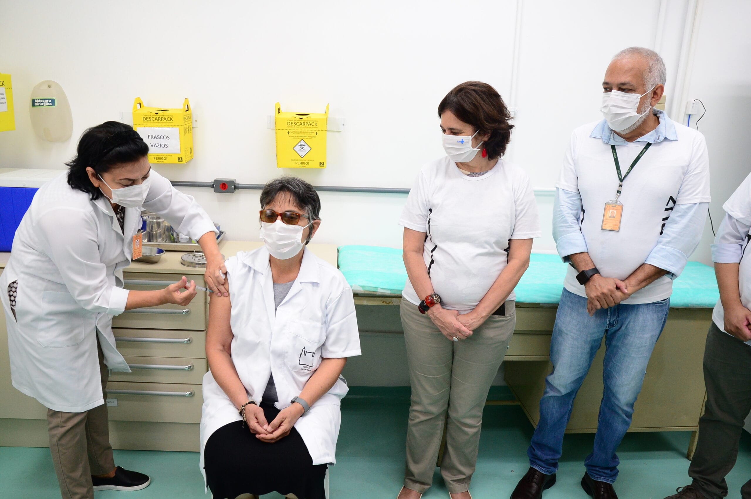 A médica Celina Borga, a primeira profissional da Fiocruz a receber a vacina da covid-19 no Centro de Saúde Escola Germano Sinval Faria (CSEGSF/Ensp). Ao seu lado, Nísia Trindade Lima, presidente da Fiocruz, e Hermano Castro, diretor da Escola Nacional de Saúde Sergio Arouca (ENSP)/Fiocruz. Rio de Janeiro (RJ), 20 jan. 2021. Foto: Peter Ilicciev/CCS/Fiocruz.